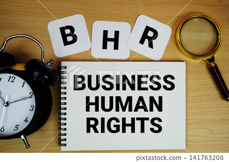 BHR Business Human Rights text written on notepad with magnifying glass and alarm clock on wooden background 141763208