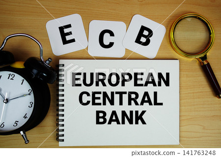 ECB European Central Bank text written on notepad with magnifying glass and alarm clock on wooden background ECB European Central Bank text written on notepad with magnifying glass and alarm clock on wooden background 141763248