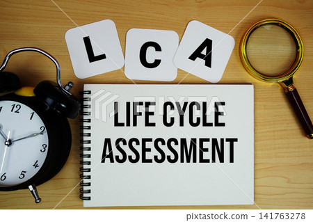 LCA Life Cycle Assessment text written on notepad with magnifying glass and alarm clock on wooden background LCA Life Cycle Assessment text written on notepad with magnifying glass and alarm clock on wooden background 141763278