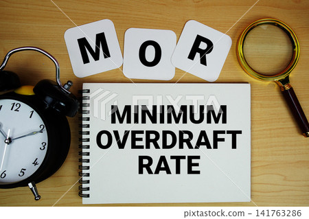MOR Minimum Overdraft Rate text written on notepad with magnifying glass and alarm clock on wooden background MOR Minimum Overdraft Rate text written on notepad with magnifying glass and alarm clock on wooden background 141763286