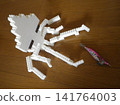A squid reaching out to grab a lure placed on the floor. 141764003