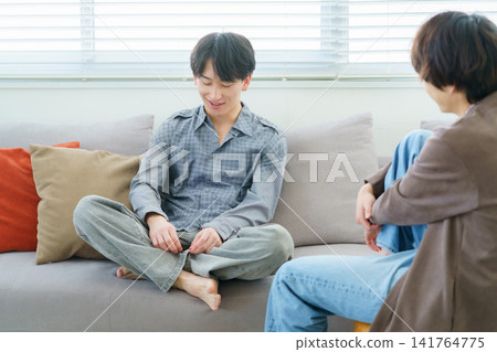 Japanese man sitting on a sofa and having a conversation Japanese man sitting on a sofa and having a conversation 141764775