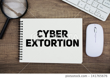 Cyber Extortion message with keyboard and optical mouse on wooden background Cyber Extortion message with keyboard and optical mouse on wooden background 141765676