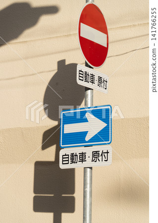 No entry and one-way street signs cast shadows on the wall. No entry and one-way street signs cast shadows on the wall. 141766255