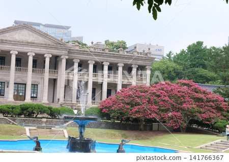 Blooming crape myrtle in front of Western-style palace building in summer Blooming crape myrtle in front of Western-style palace building in summer 141766367