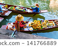 Traditional vendors selling fresh tropical fruit from wooden boats at the famous Damnoen Saduak Floating Market near Bangkok in Thailand. 141766889