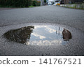 The sky reflected in the puddle 141767521