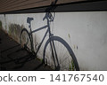 The silhouettes of a bicycle and summer grass projected onto the wall 141767540