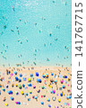 Aerial drone view of people relaxing on a white sand beach under colorful umbrellas. Aerial drone view of people relaxing on a white sand beach under colorful umbrellas. 141767715