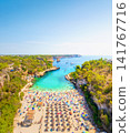 Aerial drone view of a beach with colorful umbrellas and people relaxing. Aerial drone view of a beach with colorful umbrellas and people relaxing. 141767716