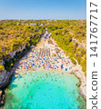 Aerial drone view of a beach with colorful umbrellas and people relaxing. Aerial drone view of a beach with colorful umbrellas and people relaxing. 141767717