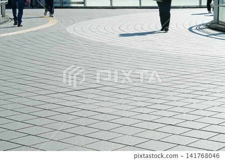 People walking on a pedestrian overpass, the sun and shadows People walking on a pedestrian overpass, the sun and shadows 141768046