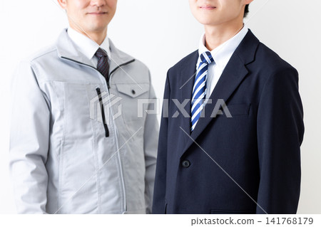 一位身穿西裝的年輕男子和一位身穿工作服的中年男子。 141768179