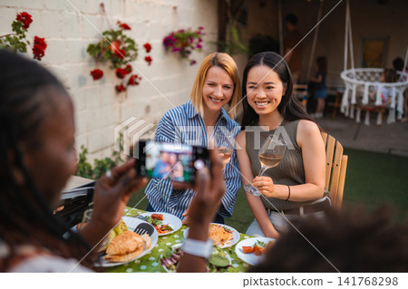 Diverse adult women enjoying outdoor party while taking picture Diverse adult women enjoying outdoor party while taking picture 141768298