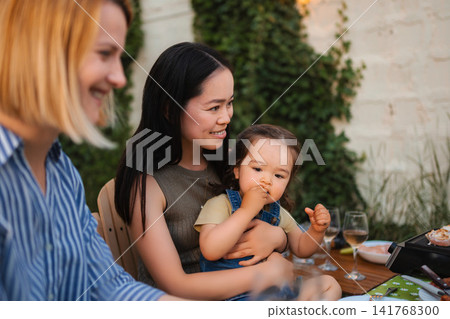 Mixed age family enjoying happy outdoor dinner together Mixed age family enjoying happy outdoor dinner together 141768300