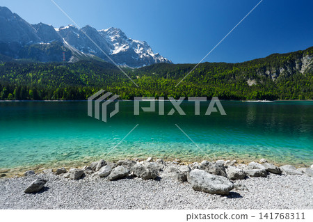 Travel landscape of Zugspitze Alps in Bavaria, Germany, scenic summer nature panorama with forest, Eibsee lake, snow mountains peak. Alpine landscape Travel landscape of Zugspitze Alps in Bavaria, Germany, scenic summer nature panorama with forest, Eibsee lake, snow mountains peak. Alpine landscape 141768311