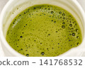 Close-up of freshly prepared matcha tea with smooth foam in a ceramic bowl. Traditional Japanese green tea ready to serve 141768532