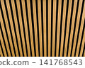 Close-up of decorative wooden slats with black gaps forming a clean geometric pattern. Natural wood texture background suitable for architecture, interior design, and abstract concepts 141768543