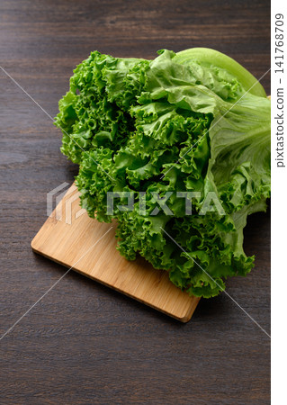 Fresh leaf lettuce placed on a wooden cutting board Fresh leaf lettuce placed on a wooden cutting board 141768709
