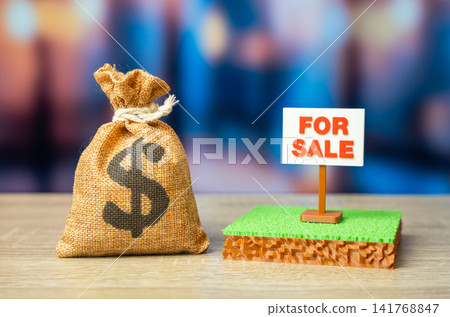 An dollar money bag and a plot of land for sale. Mortgage. Bank collateral. Land for construction or business. An dollar money bag and a plot of land for sale. Mortgage. Bank collateral. Land for construction or business. 141768847