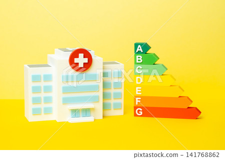A hospital and an efficiency scale. An energy efficiency rating range. Good medical performance figures and quality care standards. Healthcare excellence. Autonomy and energy efficiency. 141768862