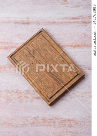 A square wooden cutting board for home food preparation. A wooden cutting board A square wooden cutting board for home food preparation. A wooden cutting board 141768999