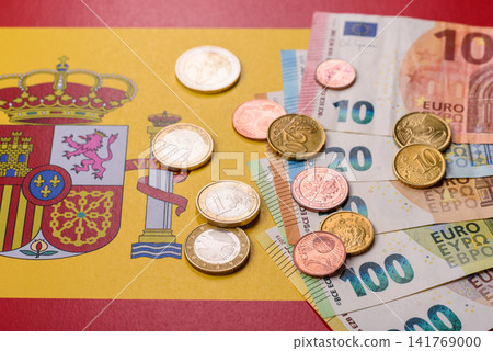 Spain, Spanish euro cash and cent coins against the background of the flag. Euro cash Spain, Spanish euro cash and cent coins against the background of the flag. Euro cash 141769000