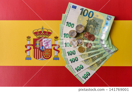 Spain, Spanish euro cash and cent coins against the background of the flag. Euro cash Spain, Spanish euro cash and cent coins against the background of the flag. Euro cash 141769001