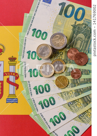 Spain, Spanish euro cash and cent coins against the background of the flag. Euro cash Spain, Spanish euro cash and cent coins against the background of the flag. Euro cash 141769002