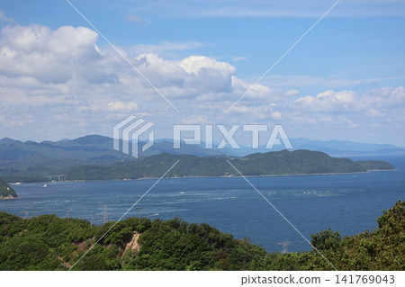 A landscape of green trees, mountains, the blue sea, ships, a peninsula, mountain ranges, clouds, and a blue sky beyond. A landscape of green trees, mountains, the blue sea, ships, a peninsula, mountain ranges, clouds, and a blue sky beyond. 141769043