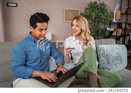 Couple online shopping using laptop and credit card 141769779