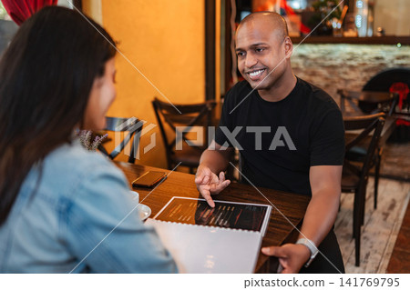 Couple choosing meal from menu in restaurant 141769795