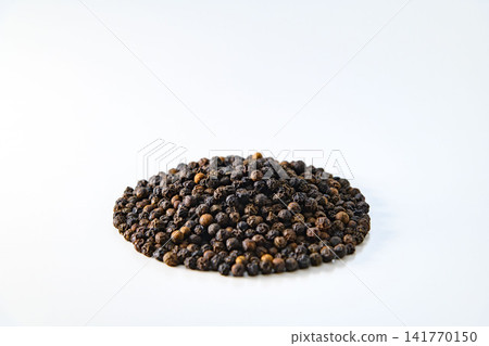 Black peppercorns spread out against a white background, texture of the ingredients. Black peppercorns spread out against a white background, texture of the ingredients. 141770150