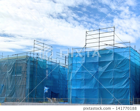 A view of a residential area with a new house under construction and scaffolding. A view of a residential area with a new house under construction and scaffolding. 141770188