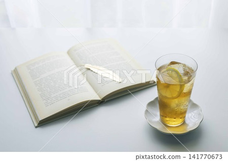A refreshing reading time with lemon iced tea and an open book. A refreshing reading time with lemon iced tea and an open book. 141770673