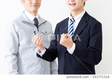 A young man in a business suit strikes a triumphant pose, while a middle-aged man in work clothes... A young man in a business suit strikes a triumphant pose, while a middle-aged man in work clothes... 141771328