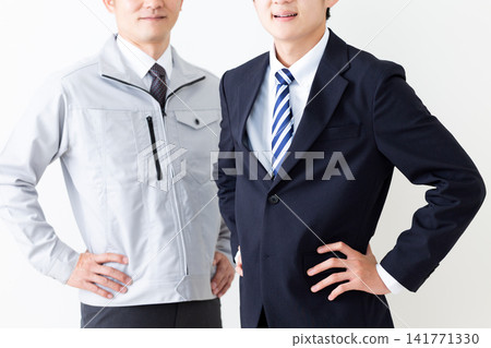 A young man in a business suit and a middle-aged man in work clothes. A young man in a business suit and a middle-aged man in work clothes. 141771330
