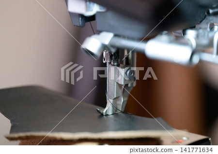 皮革工藝特寫:用工業縫紉機縫製皮革。 皮革工藝特寫:用工業縫紉機縫製皮革。 141771634