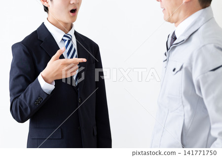 一名身穿西裝的年輕男子和一名身穿工作服的中年男子正在和他們的老闆爭論。 一名身穿西裝的年輕男子和一名身穿工作服的中年男子正在和他們的老闆爭論。 141771750