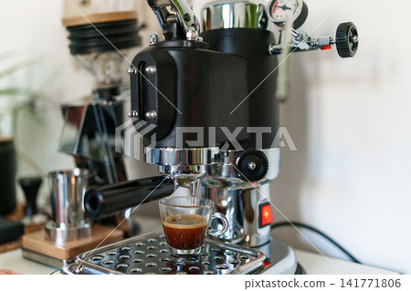 Home barista corner with a manual lever espresso machine and a single dose coffee grinder. Home barista corner with a manual lever espresso machine and a single dose coffee grinder. 141771806