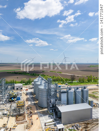 Construction of a modern agricultural grain terminal with wind turbines on the horizon Construction of a modern agricultural grain terminal with wind turbines on the horizon 141771847