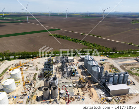 Construction of a modern agricultural grain terminal with wind turbines on the horizon Construction of a modern agricultural grain terminal with wind turbines on the horizon 141771850