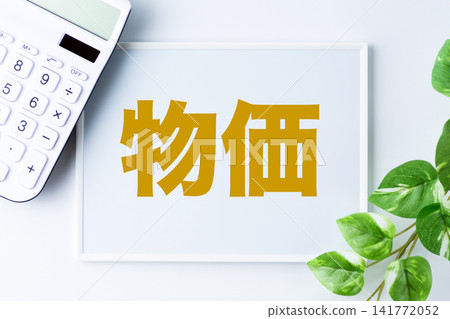 A whiteboard with the word "prices" and a white calculator A whiteboard with the word "prices" and a white calculator 141772052