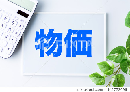 A whiteboard with the word "prices" and a white calculator A whiteboard with the word "prices" and a white calculator 141772096