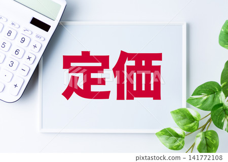 一塊寫著標價的白板和一台白色計算器 141772108