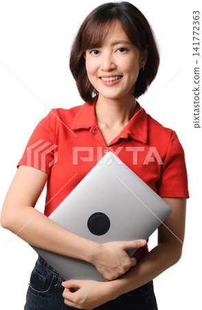 Asian woman holding laptop with confident smile in red shirt and standing against transparent background for business concept 141772363
