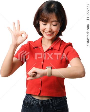 Asian woman checking smartwatch wearing red shirt with OK gesture and cheerful smile against isolated transparent background for health technology Asian woman checking smartwatch wearing red shirt with OK gesture and cheerful smile against isolated transparent background for health technology 141772367