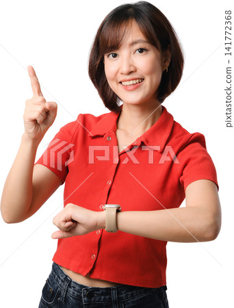 Asian woman red shirt pointing upward isolated portrait with cheerful smile and wristwatch, showing time, idea and communication concept 141772368