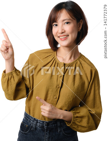 Asian woman pointing smiling mustard blouse isolated portrait, presenting welcoming gesture and confident expression for communication concept 141772379