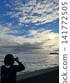 A woman photographing the sea with Enoshima Island in the background. 141772505